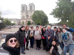 La vivienda tutelada de mujeres posa sonrientes frente a la catedral de Notre Dame en Paris junto con los miembros de la asociación Espaces Ouverts