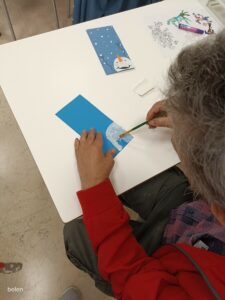 usuaria del taller de arts i oficis haciendo postales navideñas. 